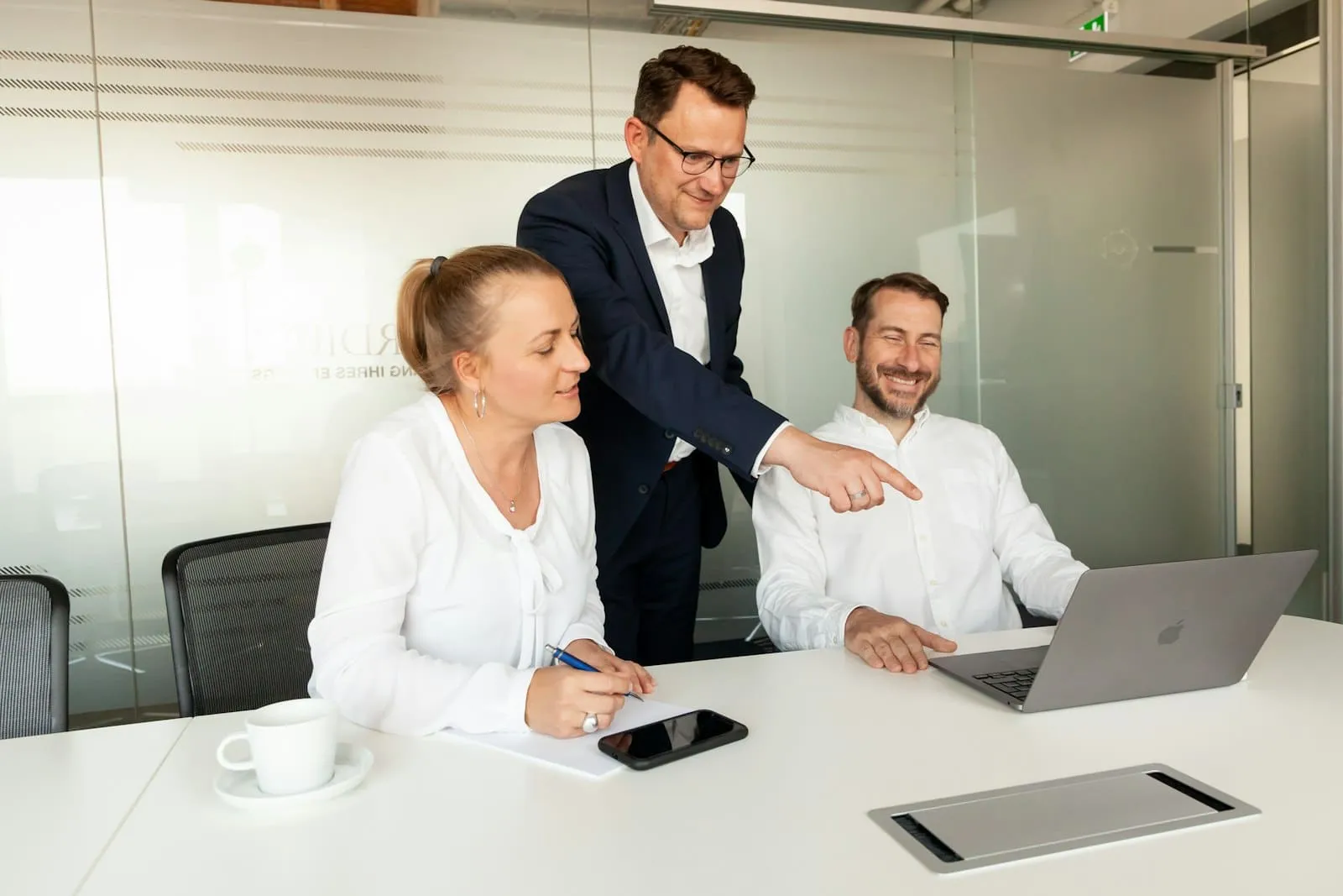 Beraterin und zwei Kollegen besprechen am Laptop ein Projekt