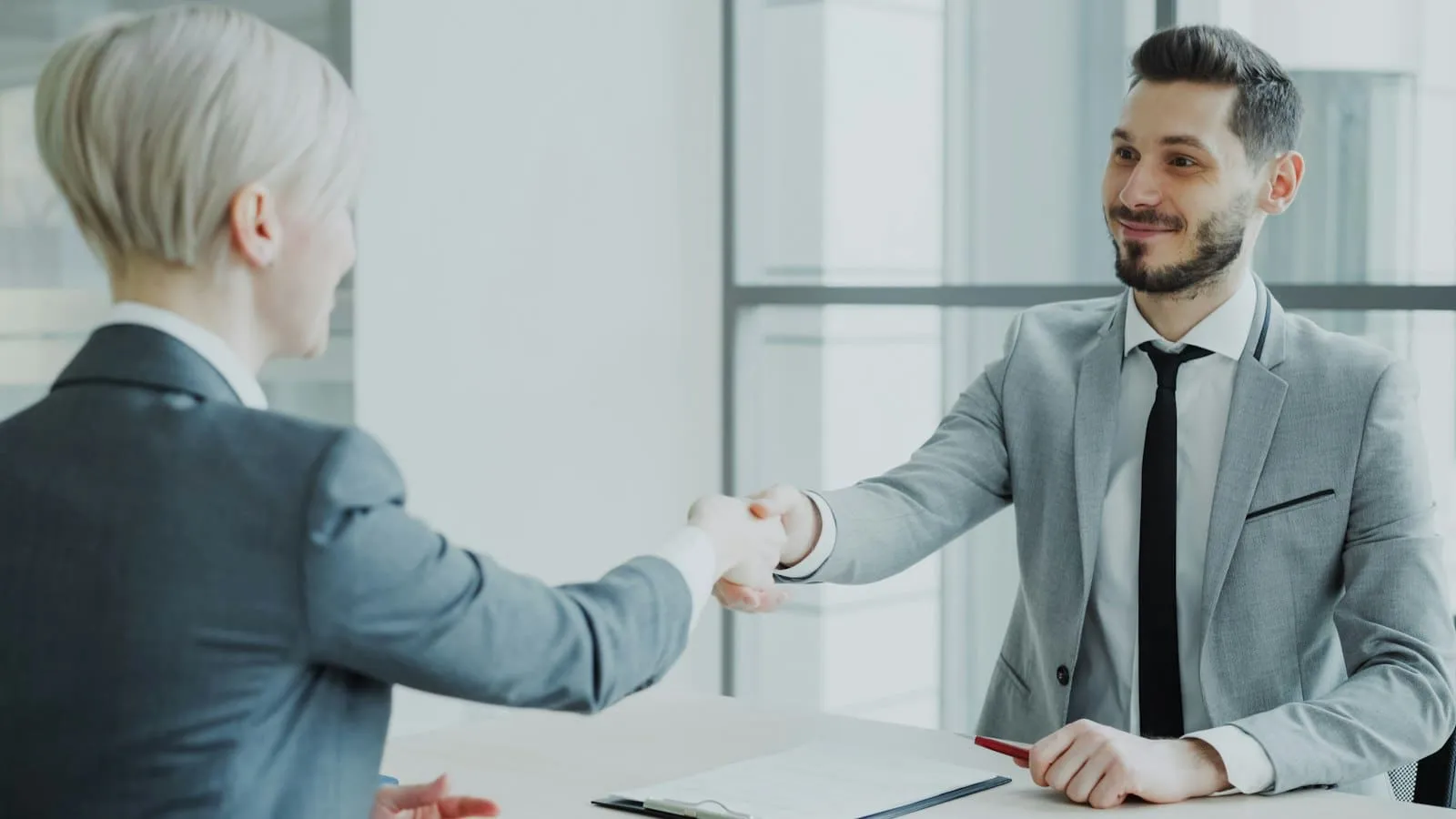 Zwei Personen geben sich nach einem Gespräch die Hand