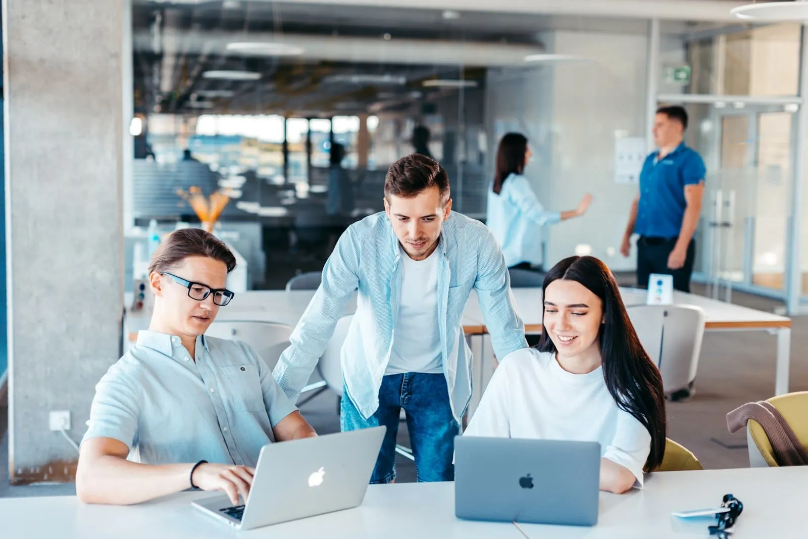 IT-Fachleute arbeiten zusammen an Laptops